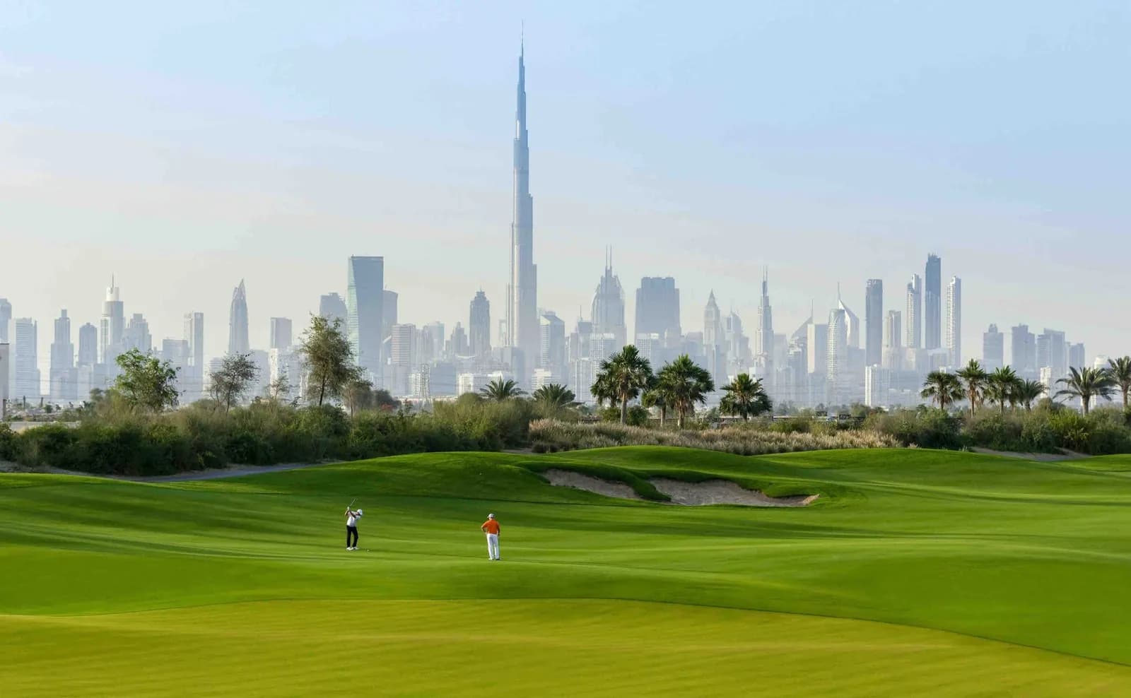 Dubai Hills golf course fairway with the Downtown Dubai skyline and Burj Khalifa behind