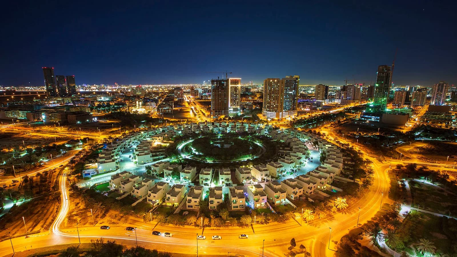 Jumeirah Village Circle lit at night with light trails along the surrounding roads