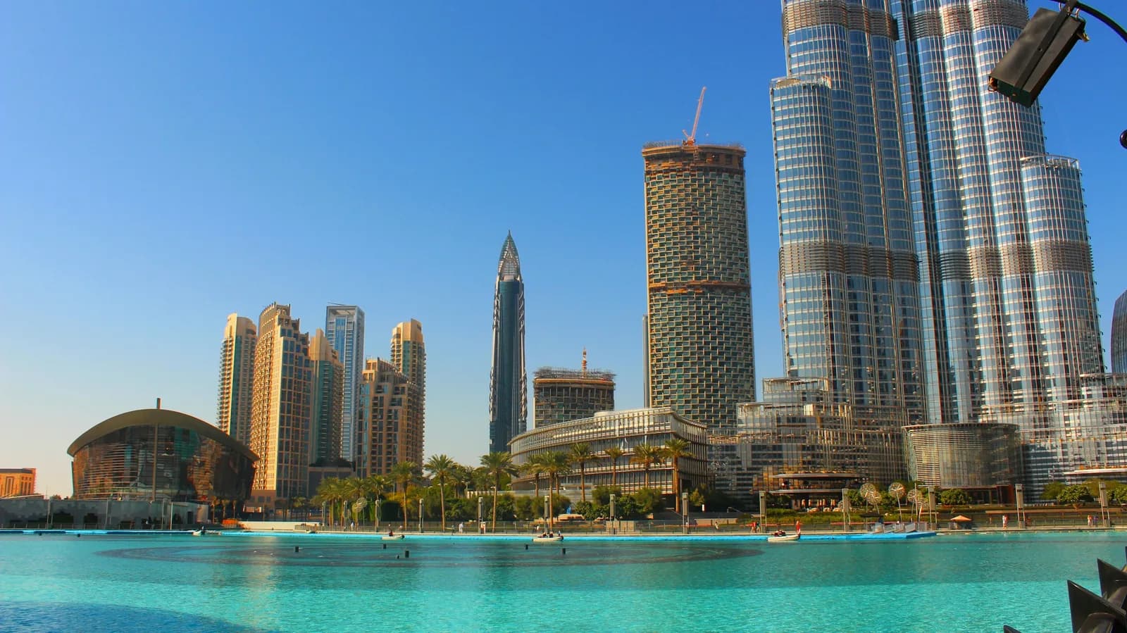Burj Lake with the Burj Khalifa and Dubai Opera under a blue sky