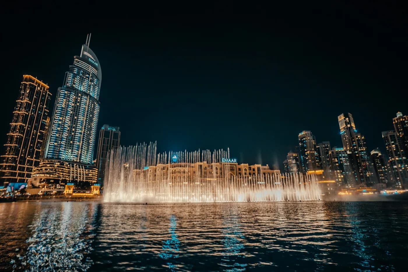 The Dubai Fountain lit up at night in front of The Dubai Mall