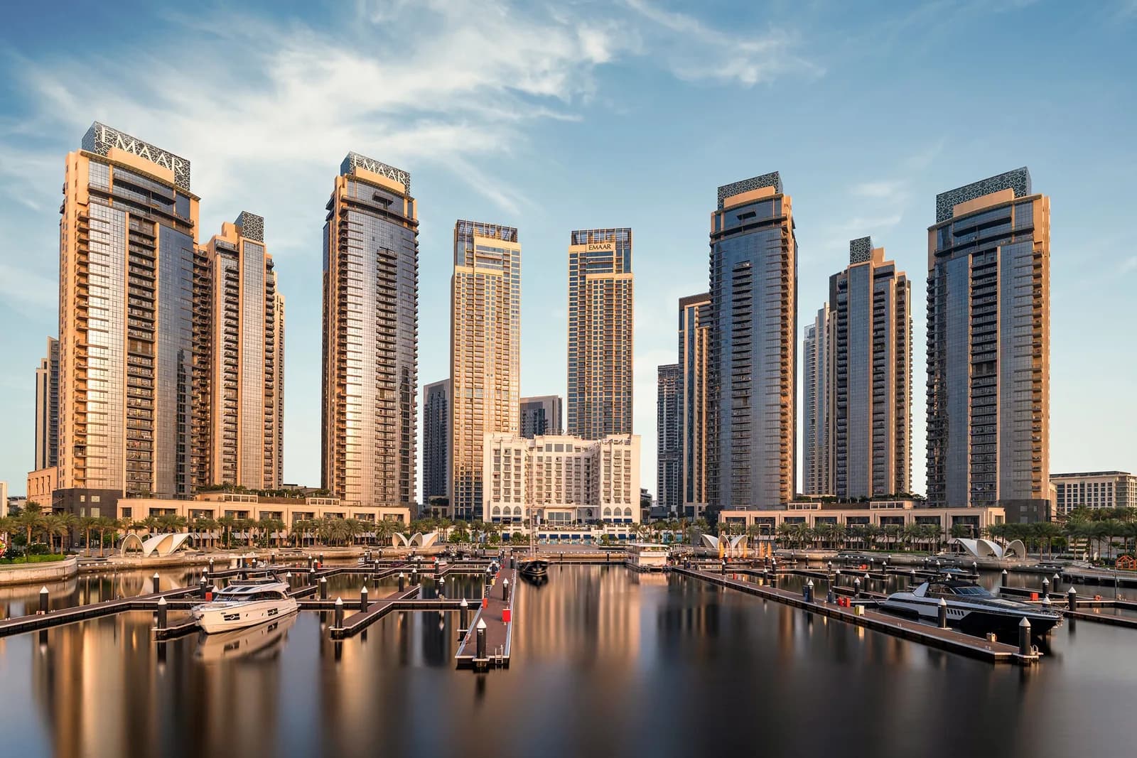 Row of residential towers rising above the Dubai Creek Harbour marina in daylight