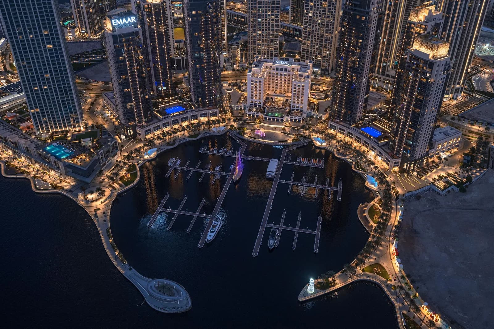 Aerial view of the Dubai Creek Harbour marina, piers and surrounding towers at dusk