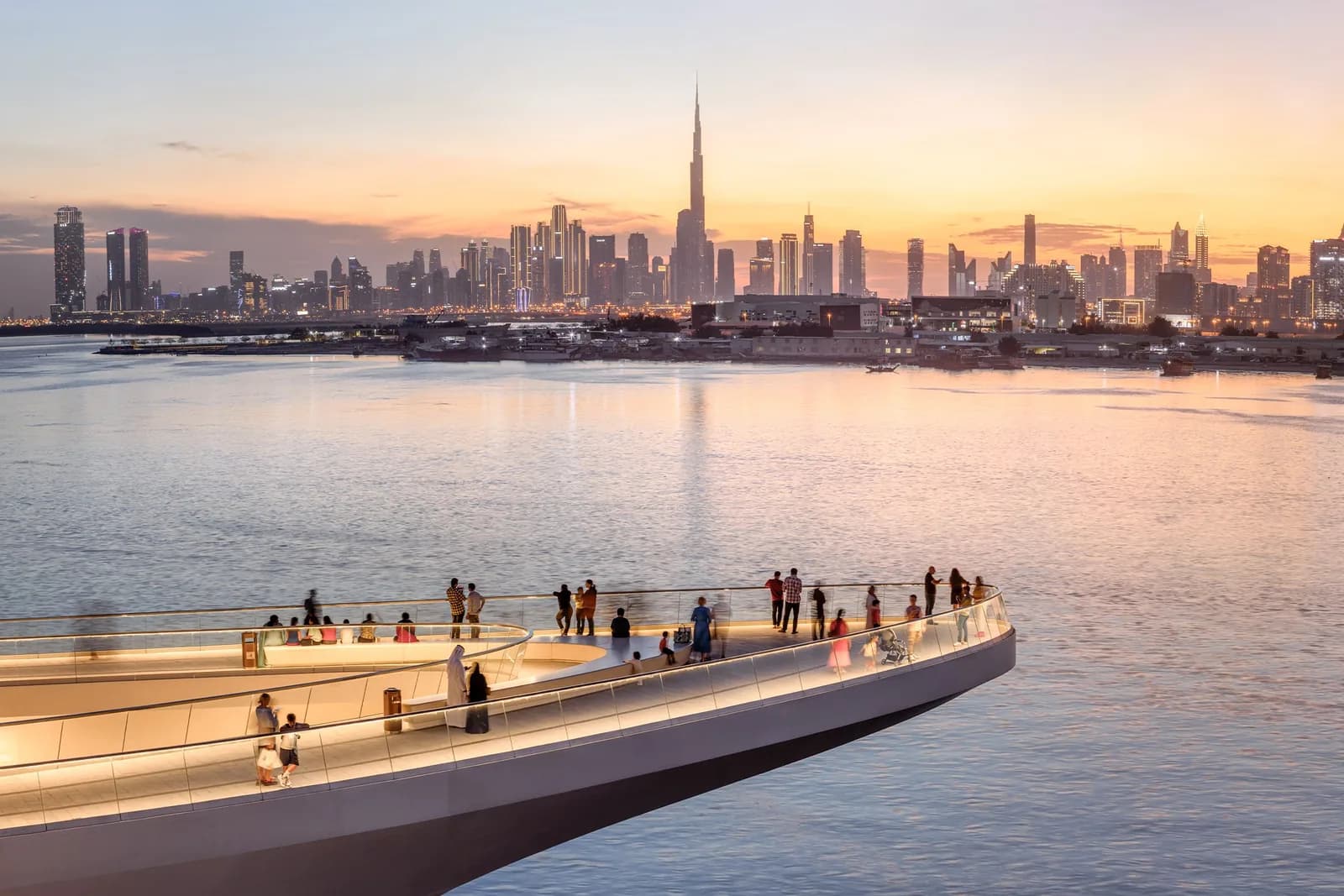 Dubai Creek Harbour viewing platform at sunset with the Burj Khalifa skyline across the water