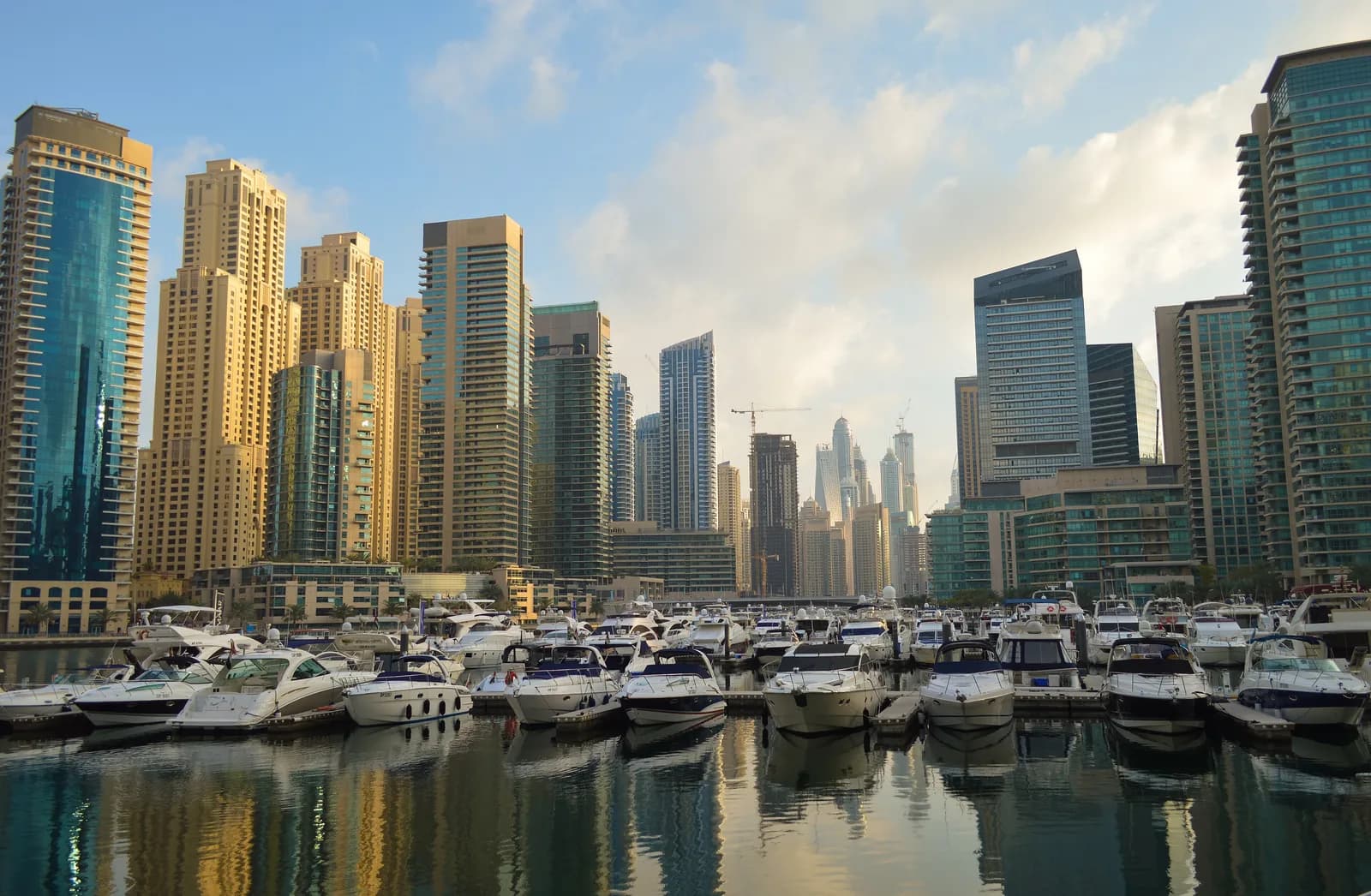 Yachts moored in Dubai Marina beneath golden-lit towers