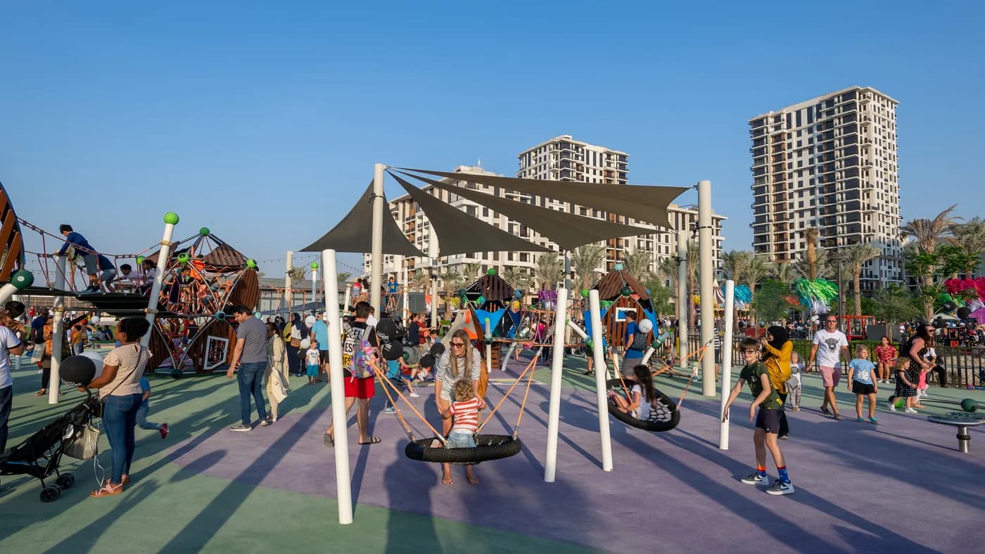 Playground with shade sails in Town Square Park, with residential towers behind